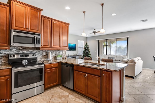 kitchen featuring hanging light fixtures, sink, ceiling fan, appliances with stainless steel finishes, and kitchen peninsula