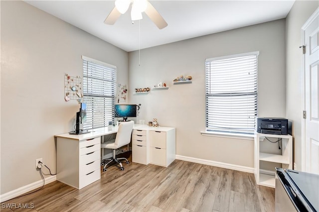 office featuring a ceiling fan, light wood-style flooring, and baseboards