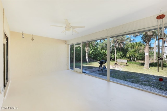 unfurnished sunroom featuring ceiling fan