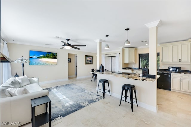 kitchen with ceiling fan, black dishwasher, dark stone countertops, cream cabinetry, and a breakfast bar