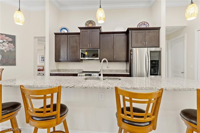 kitchen with decorative light fixtures, a breakfast bar area, and appliances with stainless steel finishes