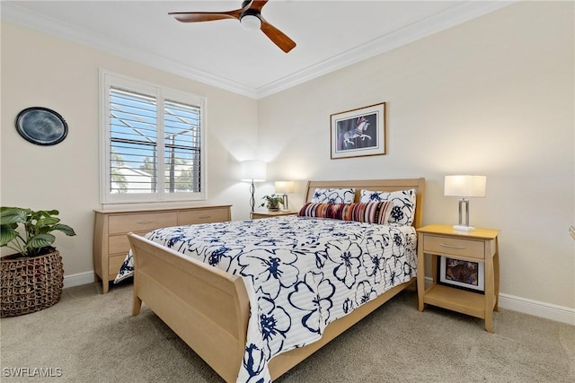 carpeted bedroom with ceiling fan and ornamental molding