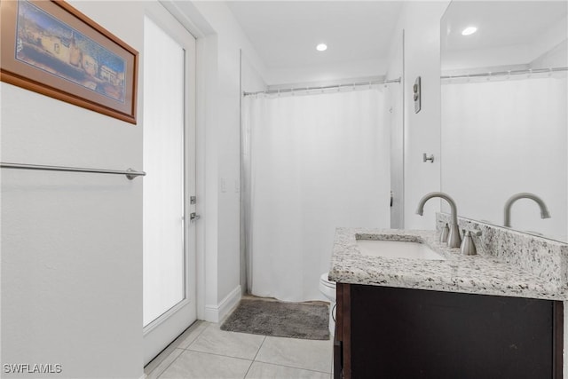 bathroom featuring tile patterned floors, walk in shower, vanity, and toilet