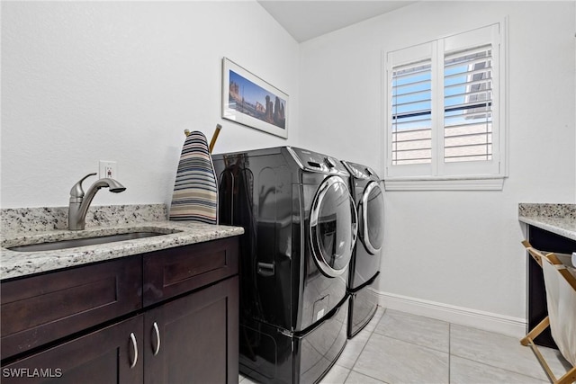 laundry area featuring cabinets, sink, light tile patterned flooring, and washer and dryer