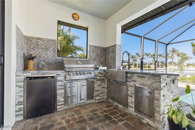 view of patio with a lanai, area for grilling, and grilling area