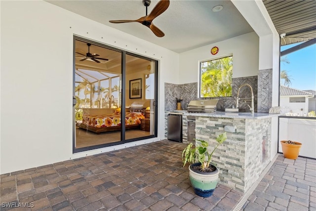 view of patio / terrace featuring grilling area, ceiling fan, sink, and an outdoor kitchen