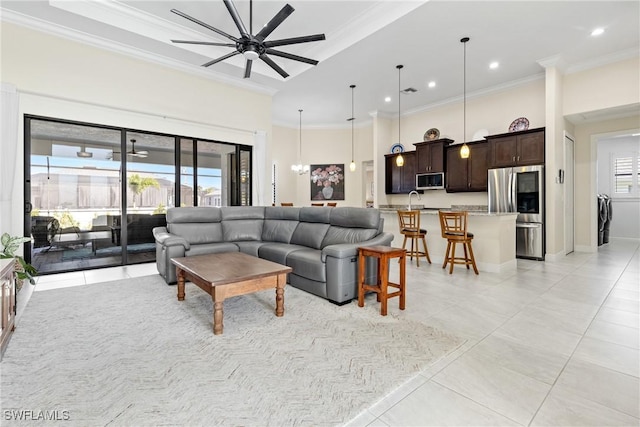 tiled living room with a wealth of natural light, sink, ceiling fan, and ornamental molding