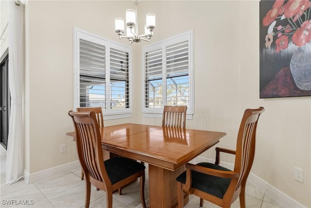 dining space with light tile patterned floors and a chandelier