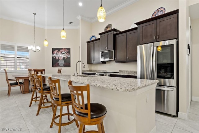 kitchen with a center island with sink, pendant lighting, and appliances with stainless steel finishes