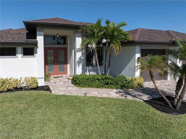 view of front of property featuring a front lawn, a garage, and french doors