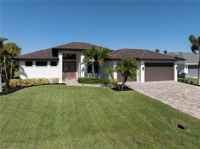 view of front of home featuring a front yard, french doors, and a garage