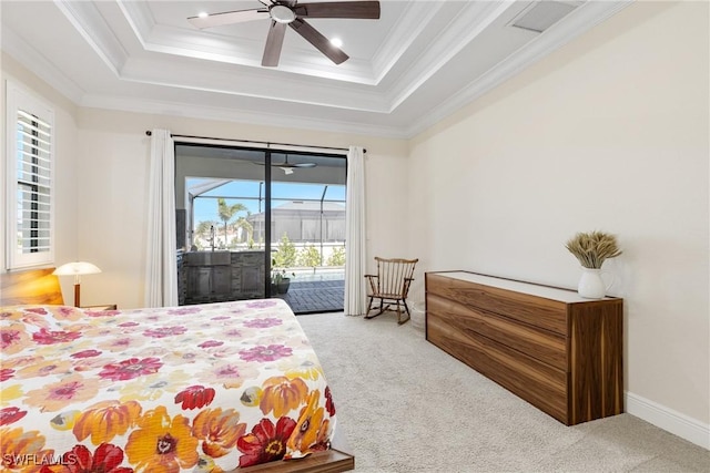 bedroom with carpet flooring, access to exterior, ceiling fan, a tray ceiling, and ornamental molding