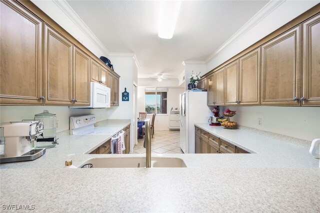 kitchen featuring light tile patterned floors, white appliances, and crown molding