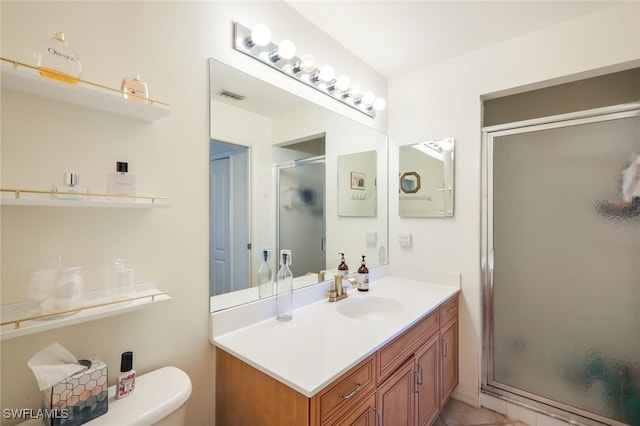 bathroom featuring vanity, tile patterned flooring, toilet, and walk in shower