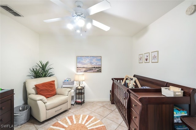 tiled bedroom with a nursery area and ceiling fan