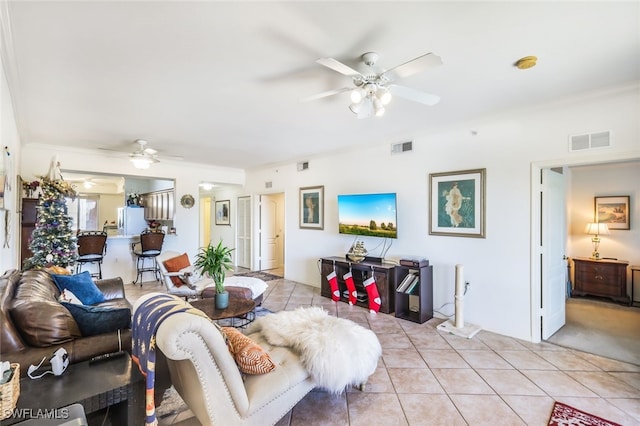 living room featuring light tile patterned flooring, crown molding, and ceiling fan