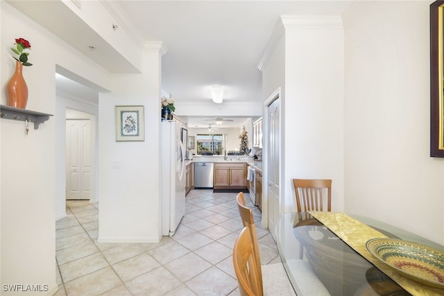 interior space with white refrigerator, stainless steel dishwasher, ornamental molding, and light tile patterned floors