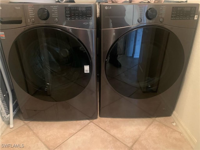 laundry area featuring tile patterned flooring and washing machine and clothes dryer