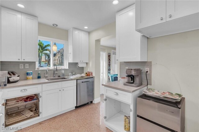 kitchen with light countertops, stainless steel dishwasher, white cabinetry, a sink, and recessed lighting