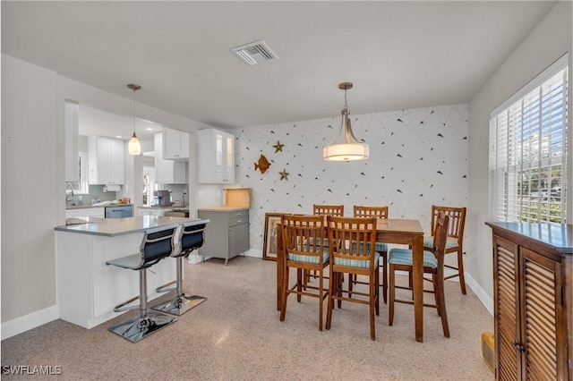 dining area with wallpapered walls, baseboards, and visible vents