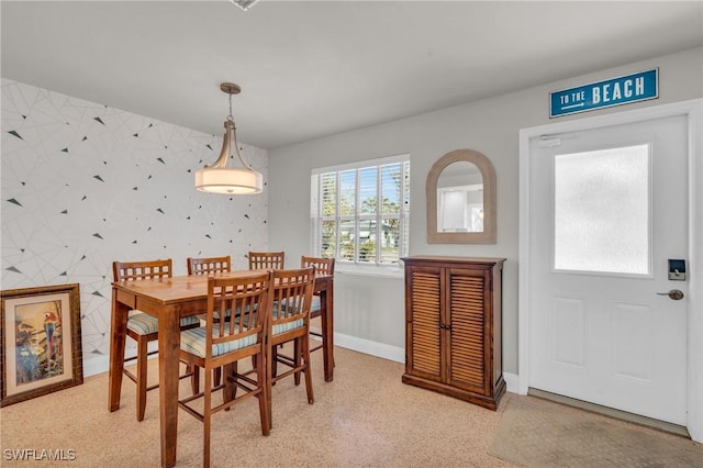 dining space with baseboards and wallpapered walls