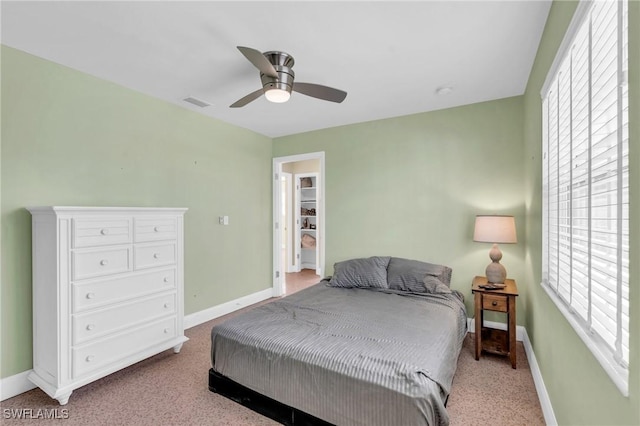 bedroom featuring light carpet, multiple windows, visible vents, and baseboards