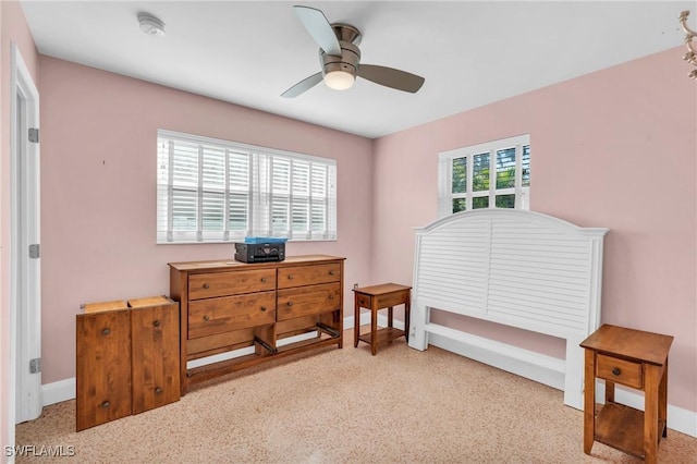 bedroom with multiple windows, a ceiling fan, and baseboards