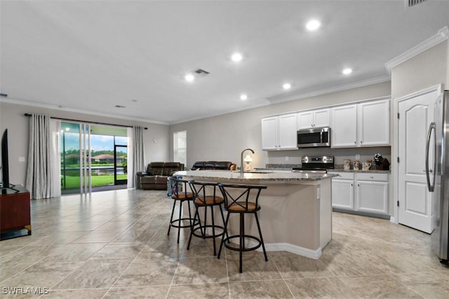 kitchen featuring white cabinets, sink, stainless steel appliances, and a kitchen island with sink