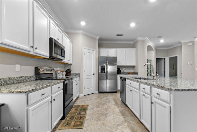 kitchen with sink, appliances with stainless steel finishes, an island with sink, white cabinets, and ornamental molding