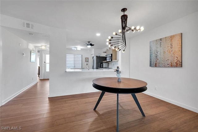 interior space with hardwood / wood-style flooring and ceiling fan with notable chandelier