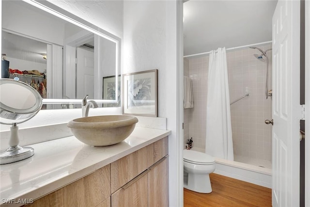 bathroom featuring hardwood / wood-style floors, vanity, toilet, and walk in shower