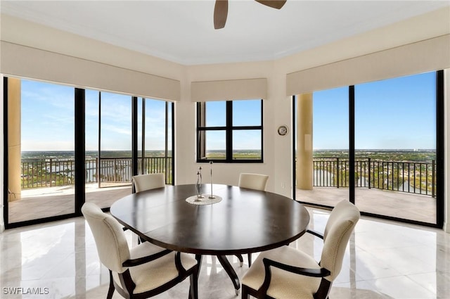 dining room featuring a wealth of natural light, a water view, ceiling fan, and crown molding