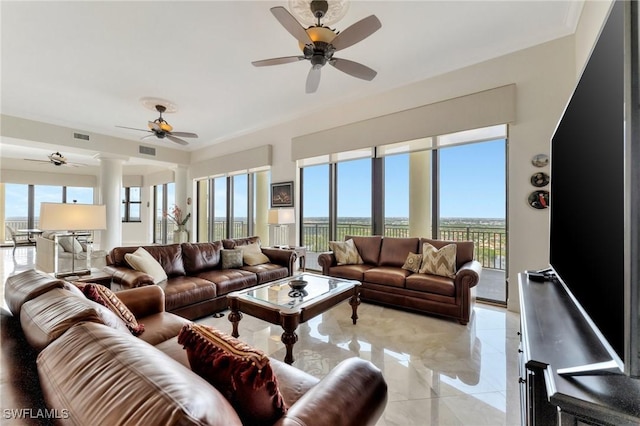 living room with decorative columns, a wealth of natural light, and ceiling fan