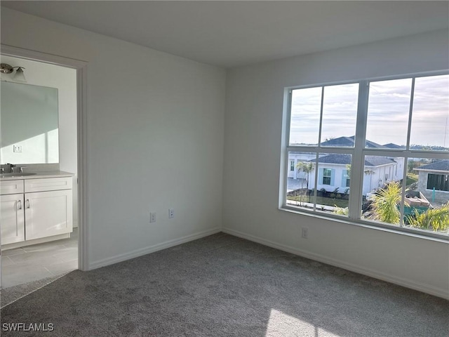 spare room with a mountain view, carpet floors, and sink