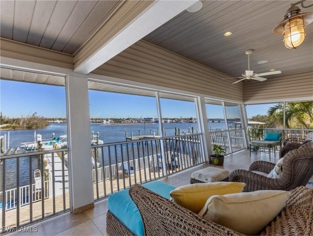 sunroom / solarium featuring a water view, ceiling fan, and wood ceiling