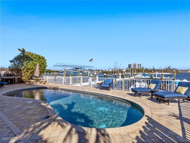 view of pool featuring a patio and a water view