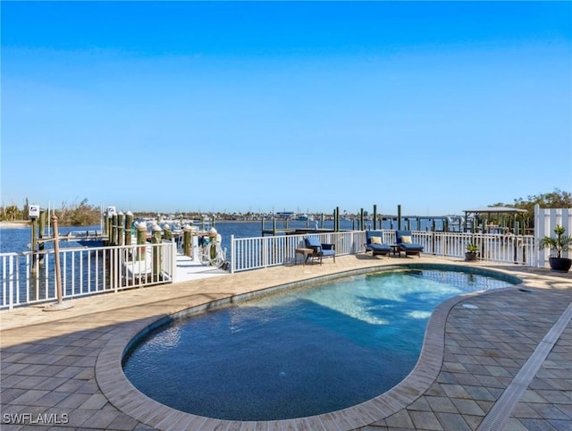 view of pool featuring a dock, a water view, and a patio