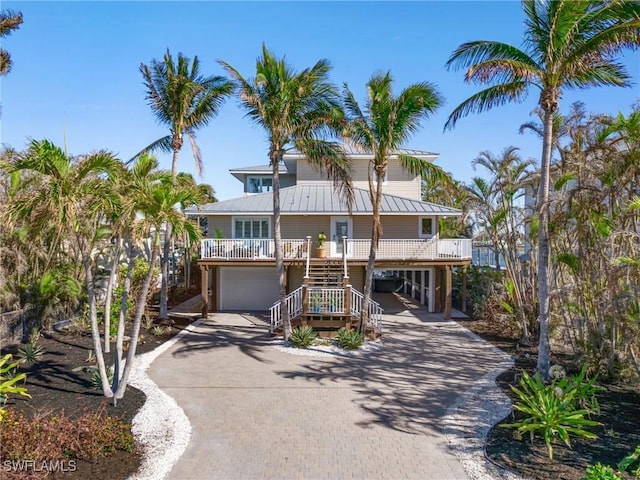 raised beach house with a porch and a garage