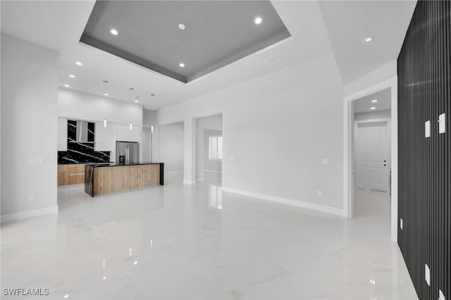 1027 NW 40th Pl, Cape Coral, FL 33993 - unfurnished living room featuring a tray ceiling, marble finish floor, baseboards, and recessed lighting