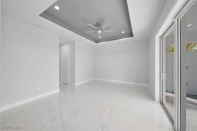 1027 NW 40th Pl, Cape Coral, FL 33993 - interior space with marble finish floor, a tray ceiling, baseboards, and ceiling fan