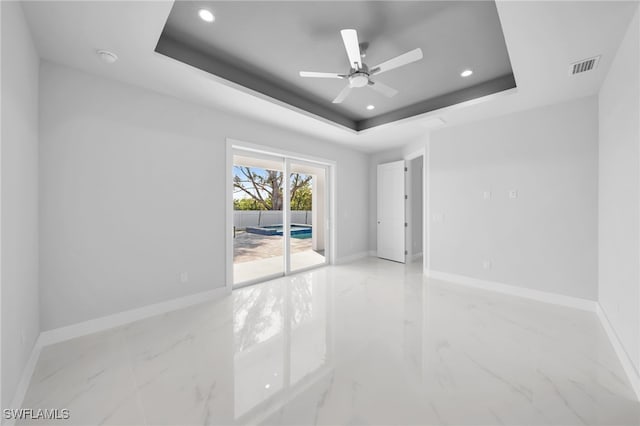 1027 NW 40th Pl, Cape Coral, FL 33993 - unfurnished room with a tray ceiling, baseboards, marble finish floor, and visible vents