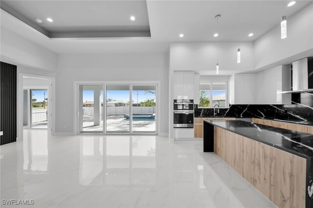 1027 NW 40th Pl, Cape Coral, FL 33993 - kitchen with a raised ceiling, marble finish floor, a high ceiling, and modern cabinets