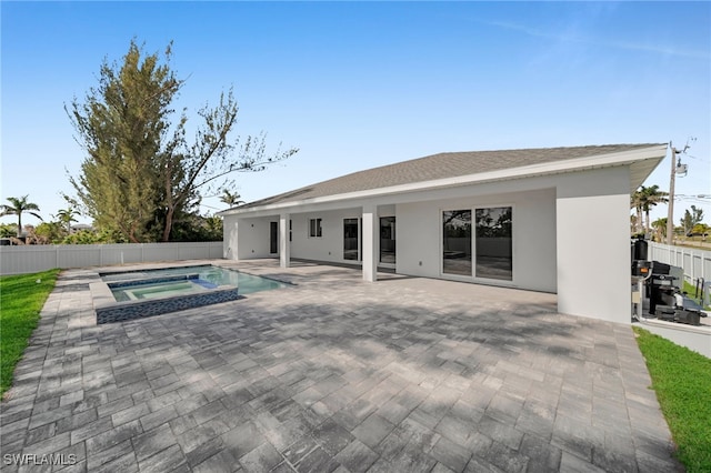 1027 NW 40th Pl, Cape Coral, FL 33993 - view of swimming pool featuring a patio, a pool with connected hot tub, and fence