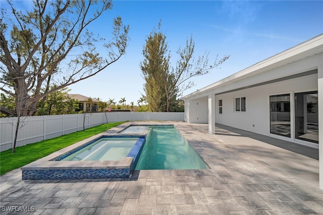 1027 NW 40th Pl, Cape Coral, FL 33993 - view of pool with a patio area, a fenced backyard, and a pool with connected hot tub