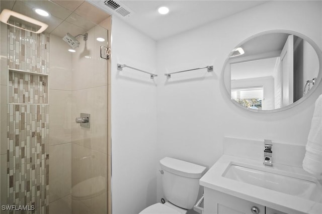 bathroom featuring vanity, a shower with shower door, and toilet