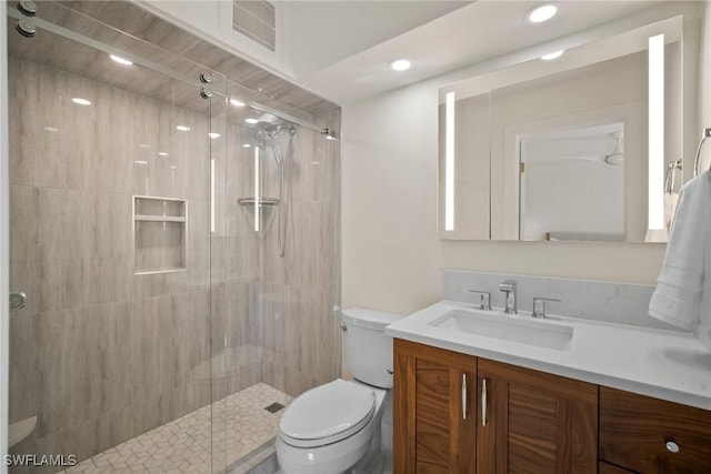 bathroom featuring vanity, toilet, and walk in shower