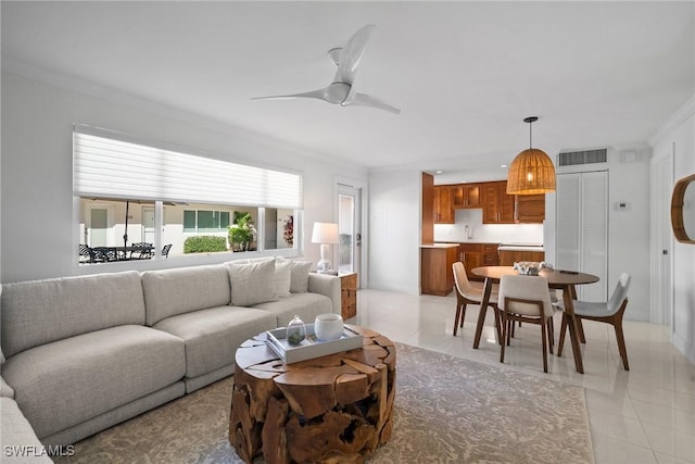 living room featuring ceiling fan, light tile patterned floors, and ornamental molding