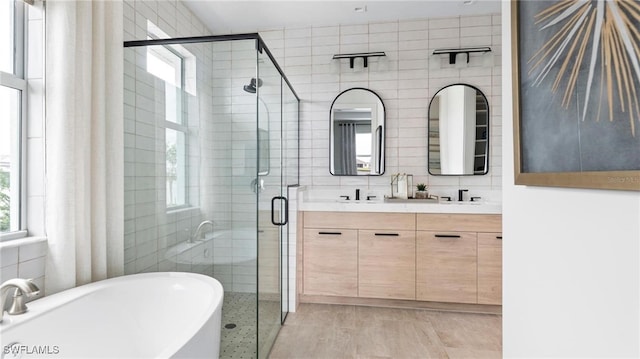 bathroom featuring plenty of natural light, independent shower and bath, and tile walls