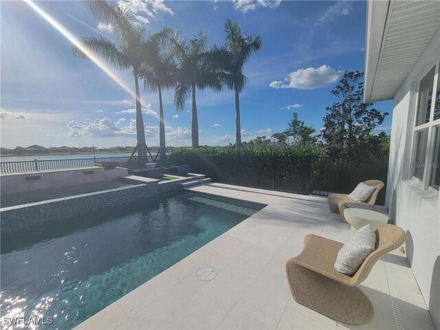 view of swimming pool featuring a patio area and a water view