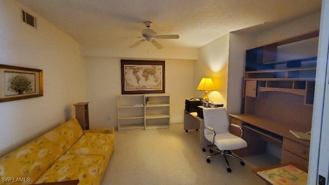 carpeted office space featuring ceiling fan and a textured ceiling